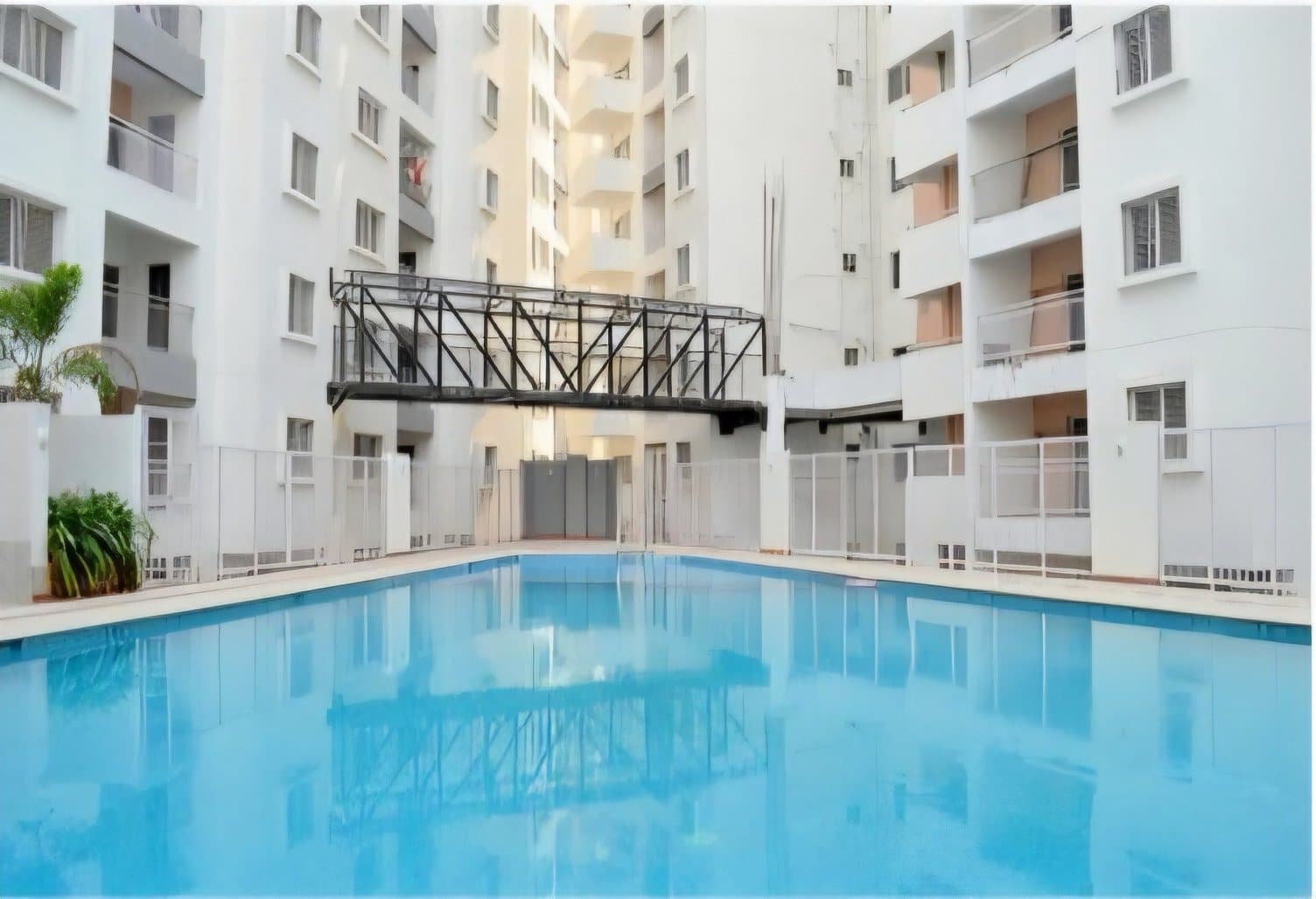The swimming pool in daylight, enclosed by the towers on three sides