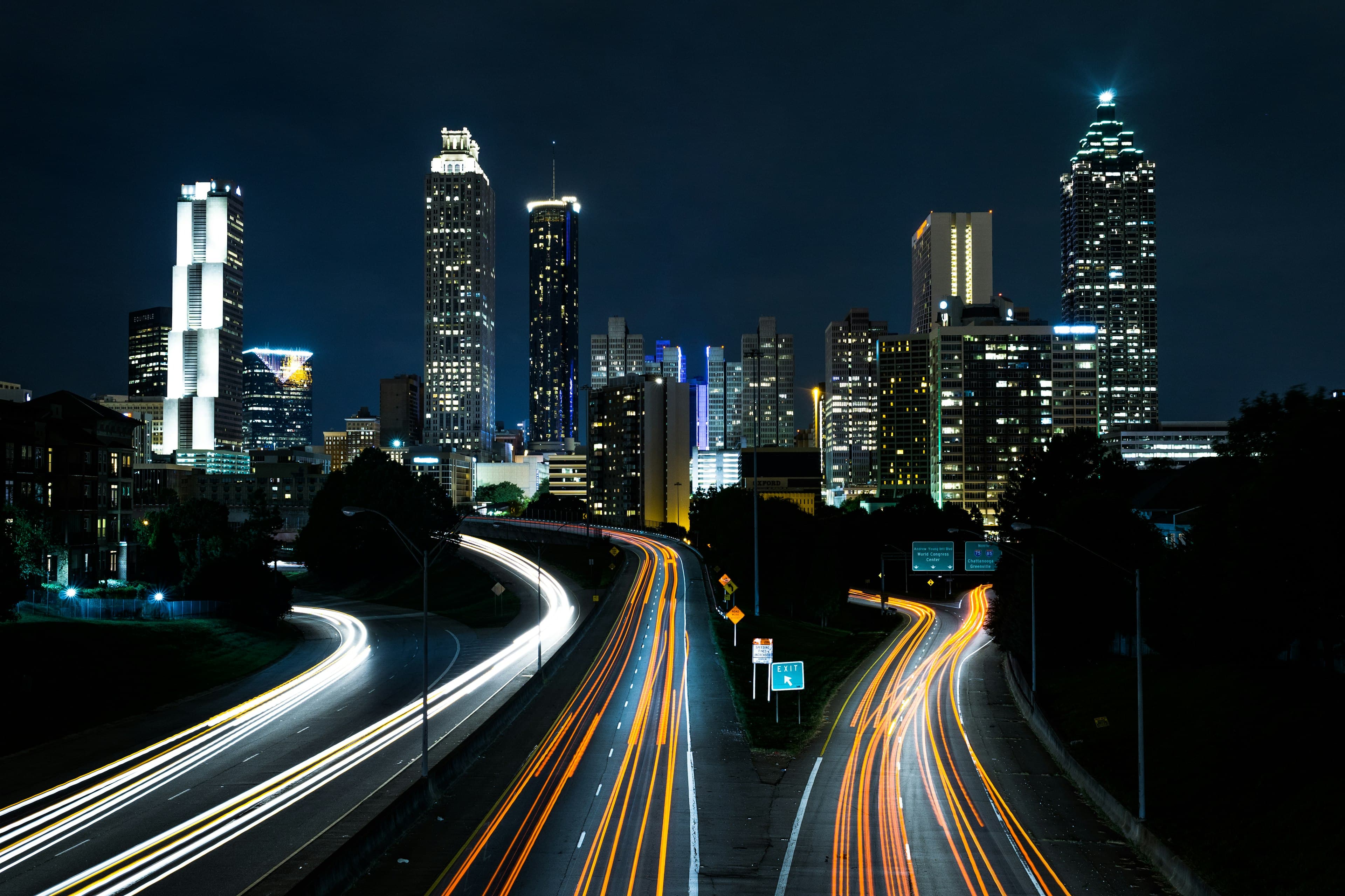 Long-exposure traffic trails running through a city at night