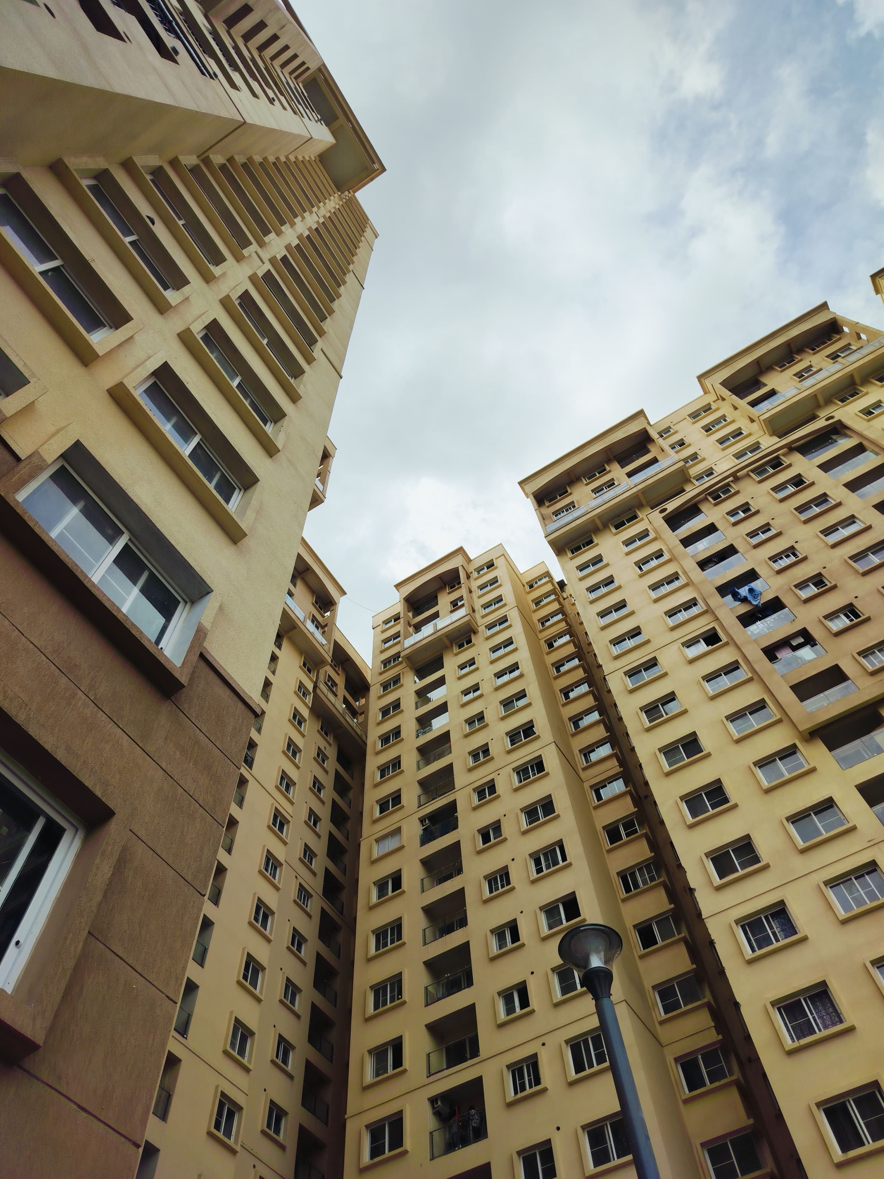 Residential towers in Bengaluru seen from the foot of the block, their balconies stepping away up the elevation